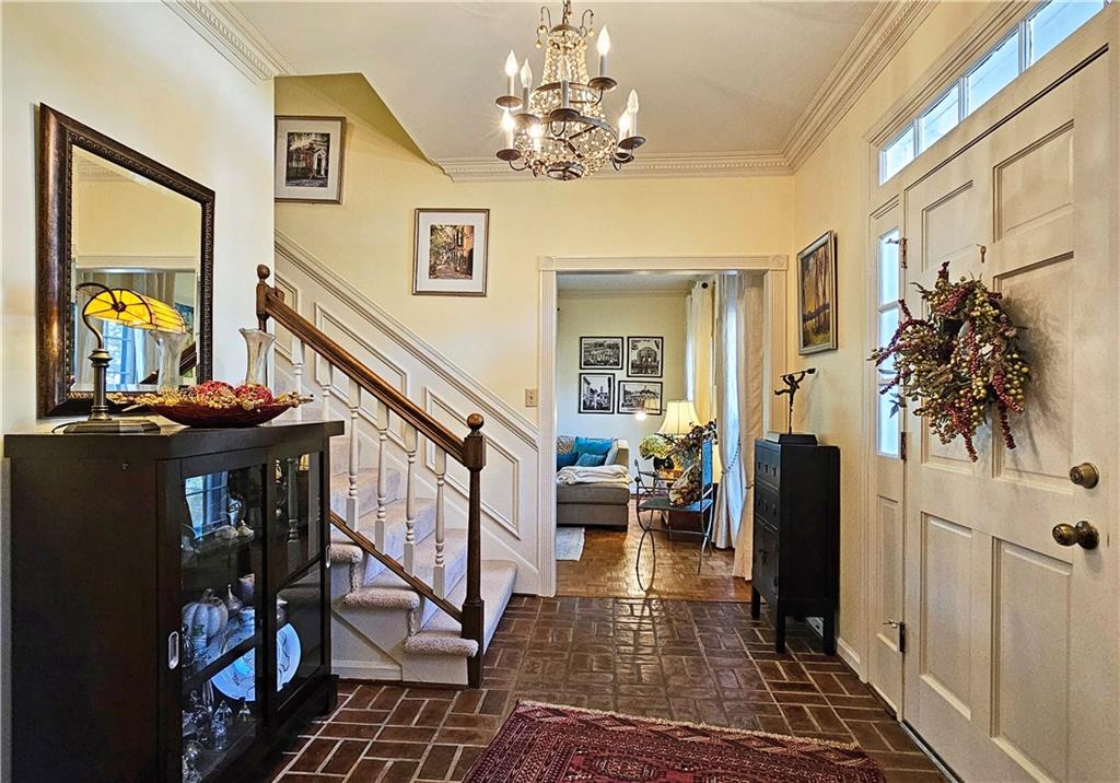 Foyer featuring crown molding and a notable chandelier
