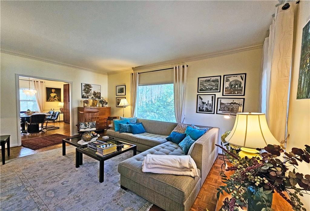 Living room featuring plenty of natural light, crown molding, a textured ceiling, and parquet floors