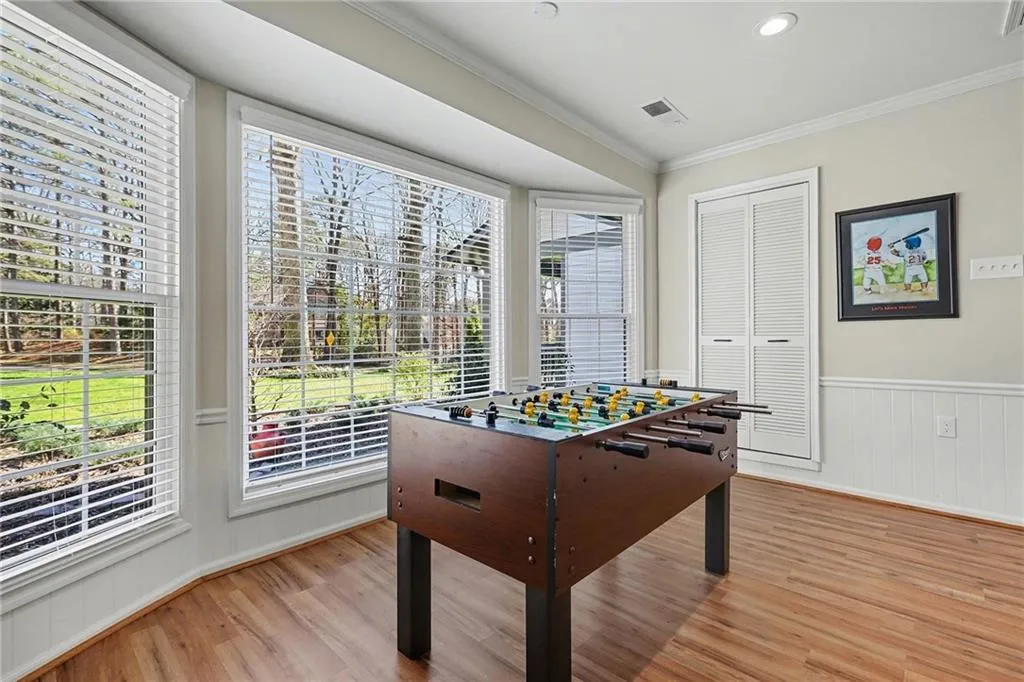 Playroom with crown molding, wainscoting, light wood-style floors, and recessed lighting