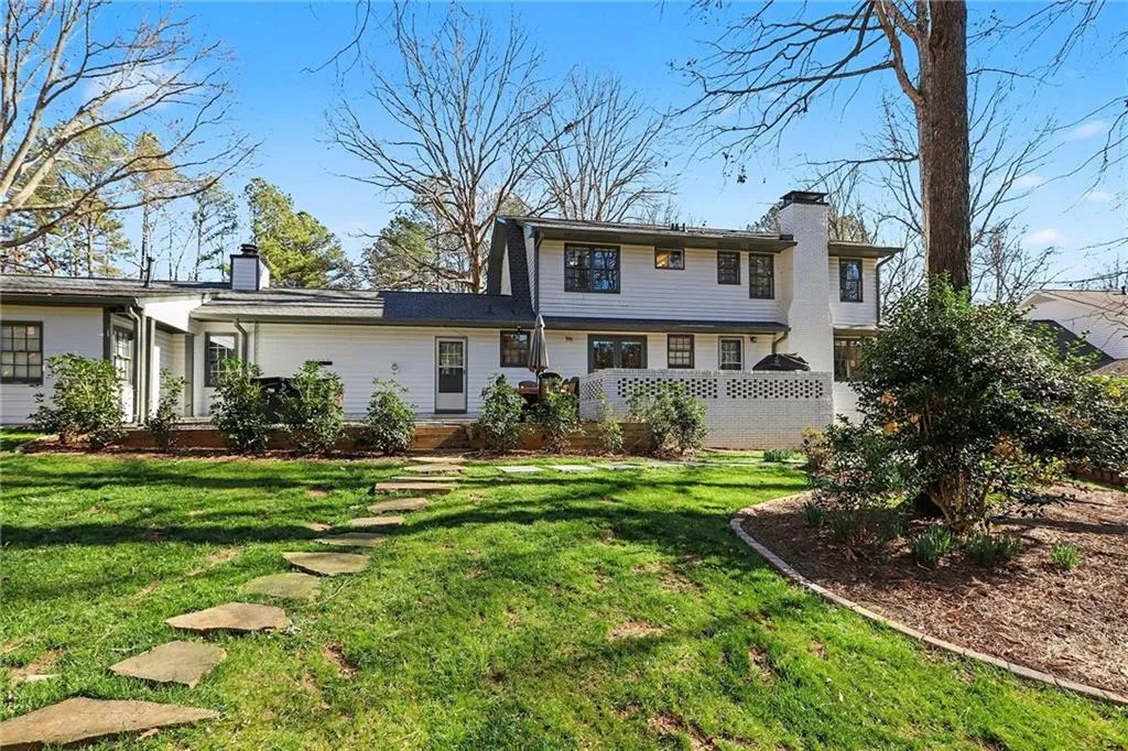 View of front of house with a chimney and a front lawn