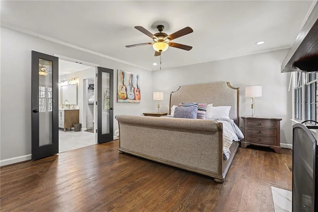 Bedroom with dark wood finished floors, crown molding, a ceiling fan, recessed lighting, and connected bathroom