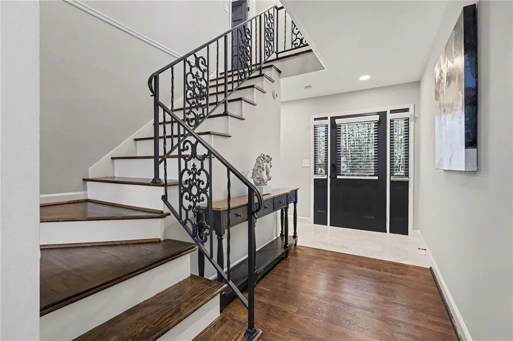 Staircase with wood finished floors and recessed lighting