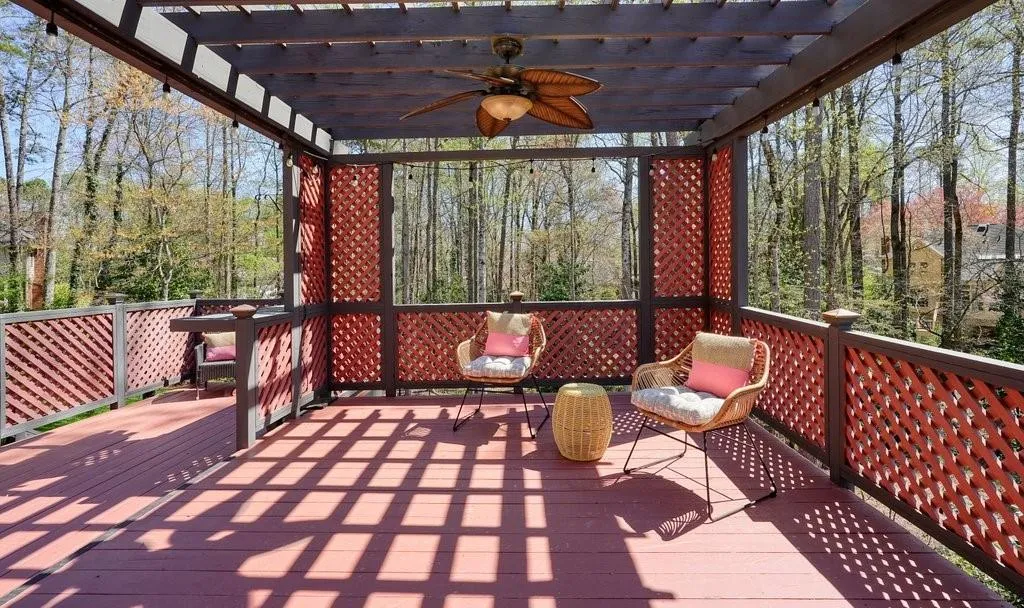 Wooden deck featuring ceiling fan and a pergola