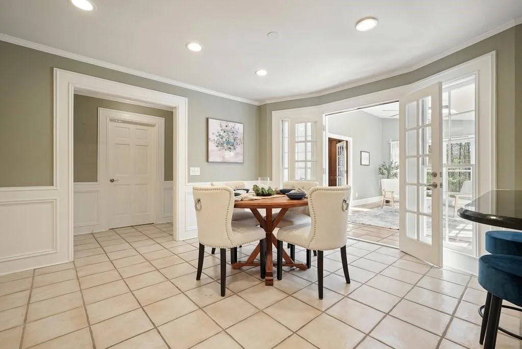 Dining space featuring french doors, light tile patterned floors, and ornamental molding
