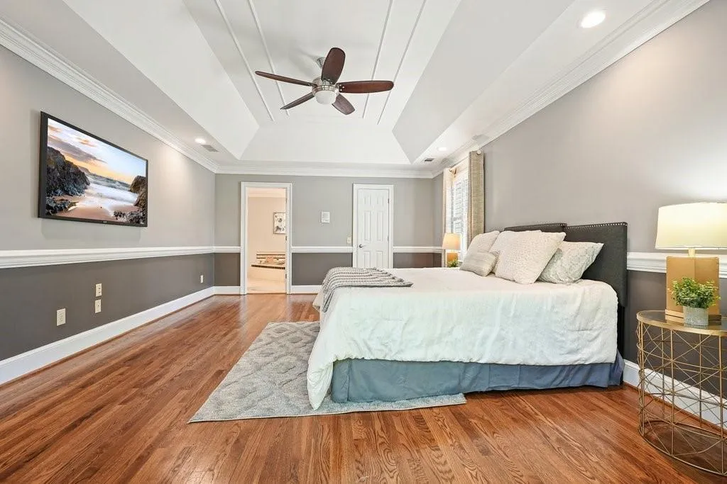 Bedroom featuring recessed lighting, baseboards, a raised ceiling, ceiling fan, and wood finished floors