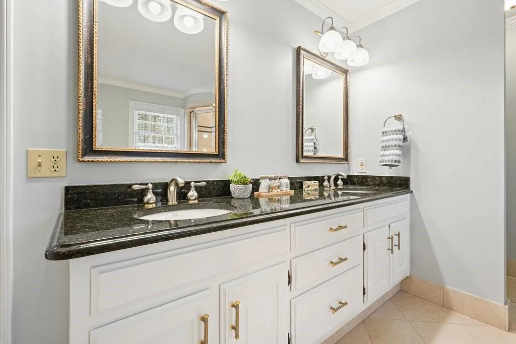 Bathroom with ornamental molding, a sink, and tile patterned flooring