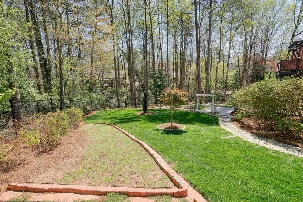 View of yard featuring fence and a view of trees
