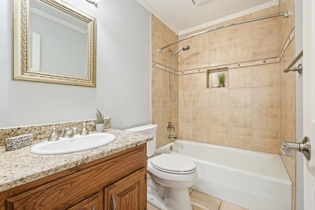 Bathroom with toilet, vanity, shower / bath combination, and crown molding