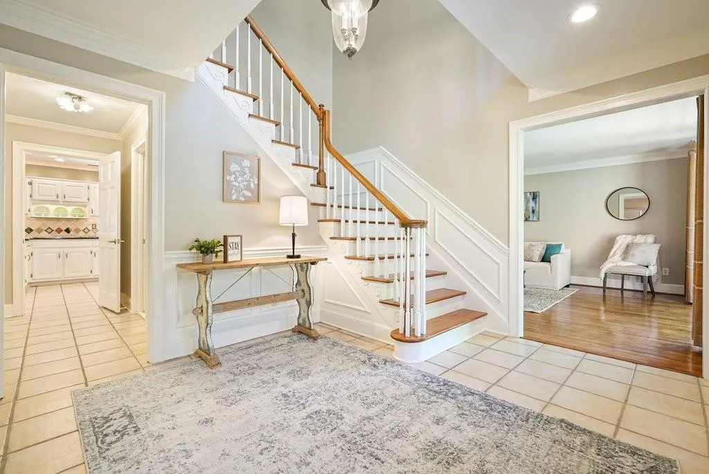Stairs featuring tile patterned floors and crown molding
