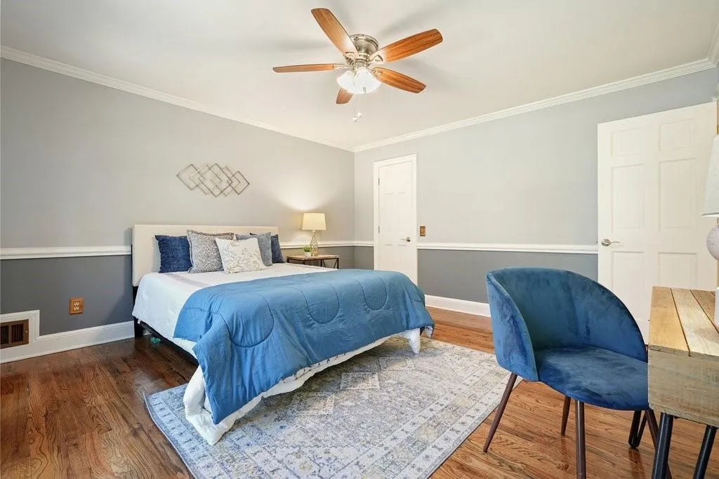 Bedroom with ornamental molding, baseboards, and wood finished floors