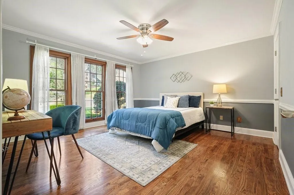 Bedroom featuring baseboards, wood finished floors, and crown molding