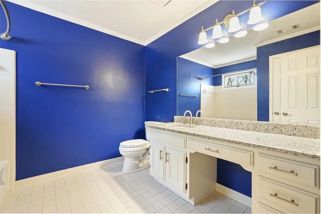 Bathroom with toilet, crown molding, a shower, and vanity