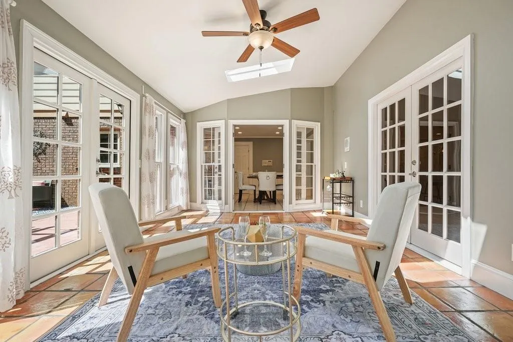 Sunroom / solarium with a wealth of natural light, vaulted ceiling with skylight, and french doors