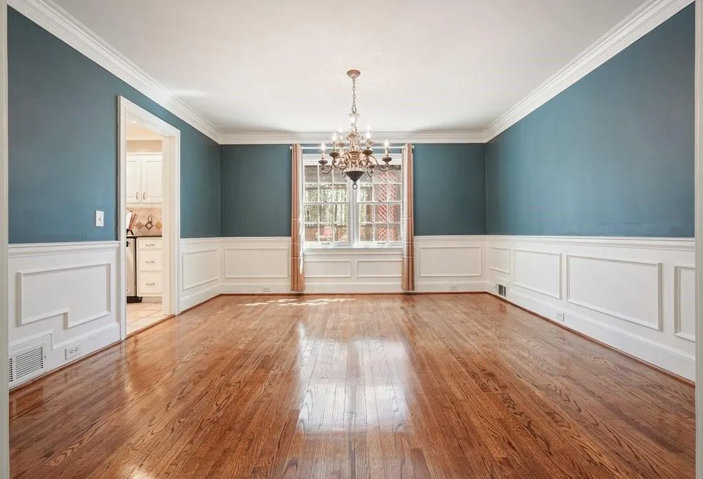 Unfurnished dining area with ornamental molding, visible vents, a notable chandelier, and hardwood / wood-style flooring