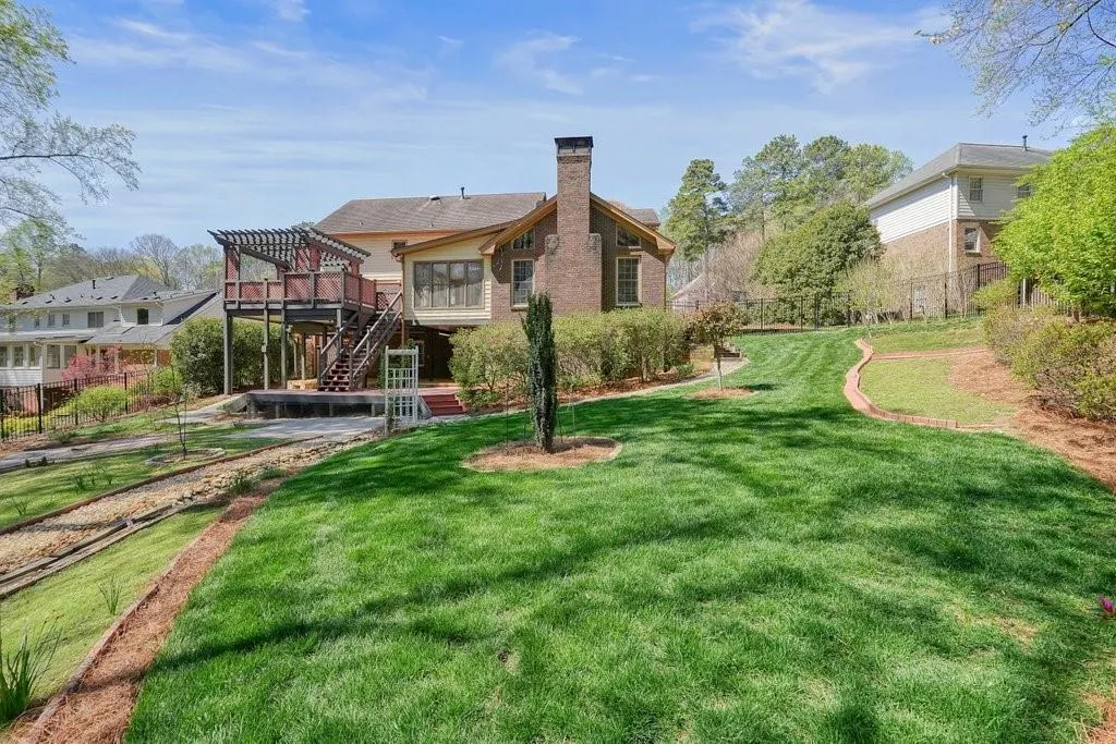 Back of house with fence, stairs, a pergola, a yard, and a chimney