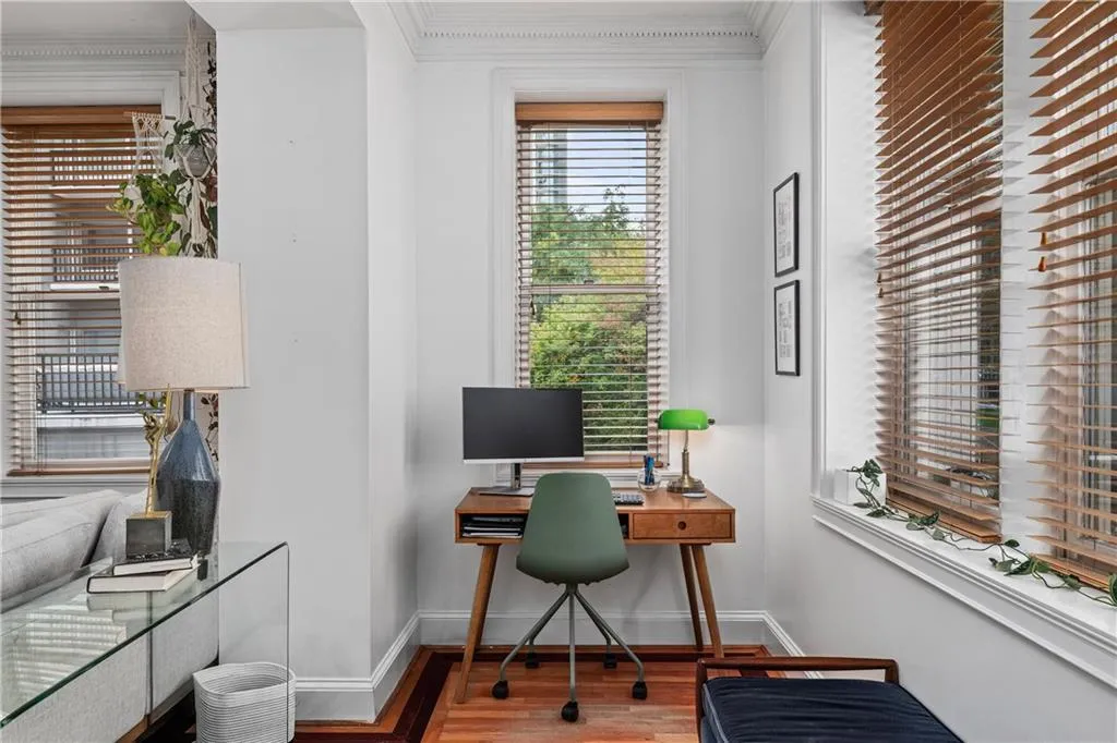 Office area with wood finished floors and crown molding