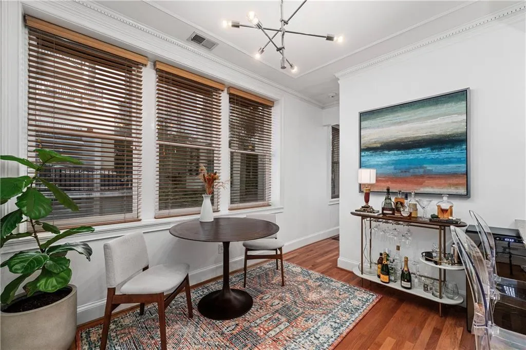 Living area featuring ornamental molding, dark wood finished floors, a chandelier, and plenty of natural light