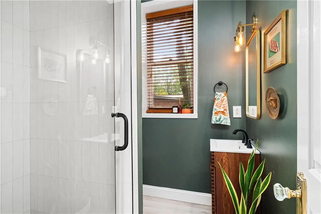 Full bathroom with vanity, wood finished floors, and a stall shower