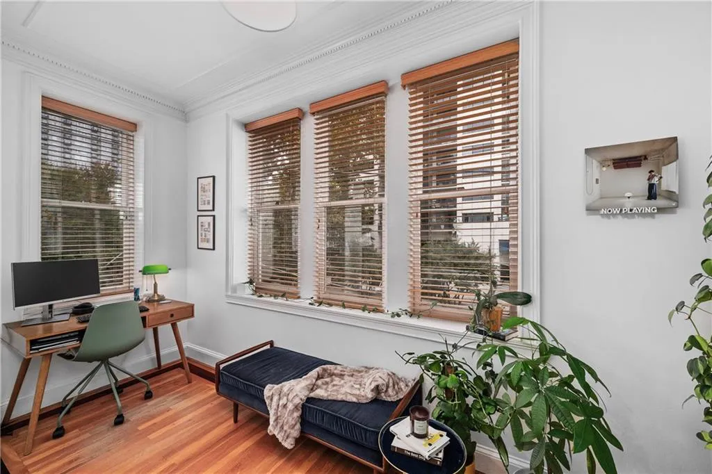 Office area featuring wood finished floors and crown molding
