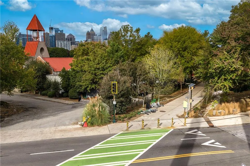 View of asphalt road featuring a view of skyline, sidewalks, and traffic signs