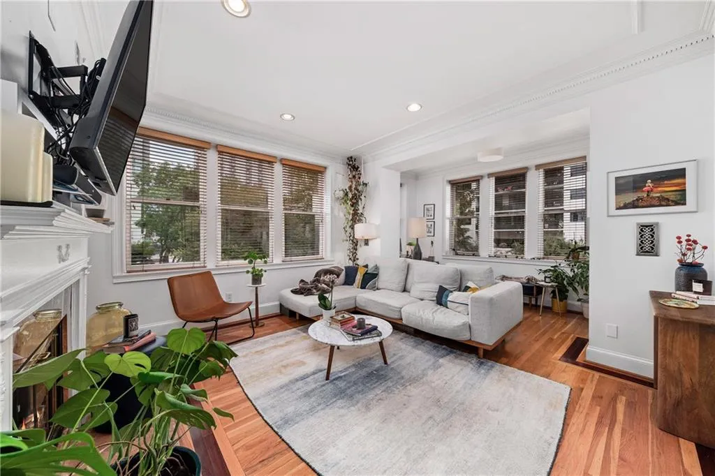 Living room with ornamental molding, a fireplace, recessed lighting, and wood finished floors