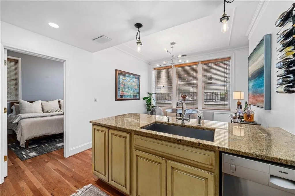 Kitchen featuring dishwasher, light wood-style floors, a peninsula, light stone countertops, and crown molding