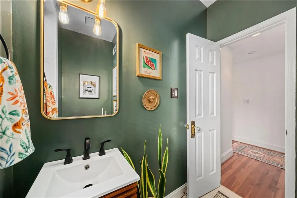 Half bathroom with vanity and wood finished floors