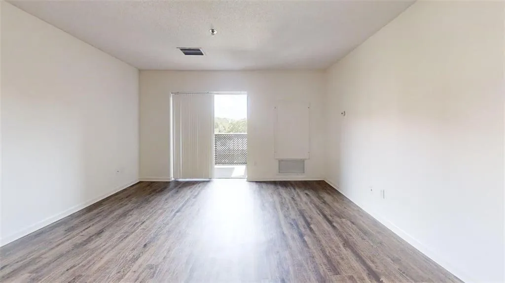 Spare room with wood finished floors and a textured ceiling