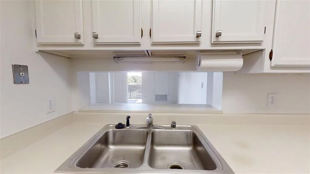 Kitchen view of white cabinets and light countertops