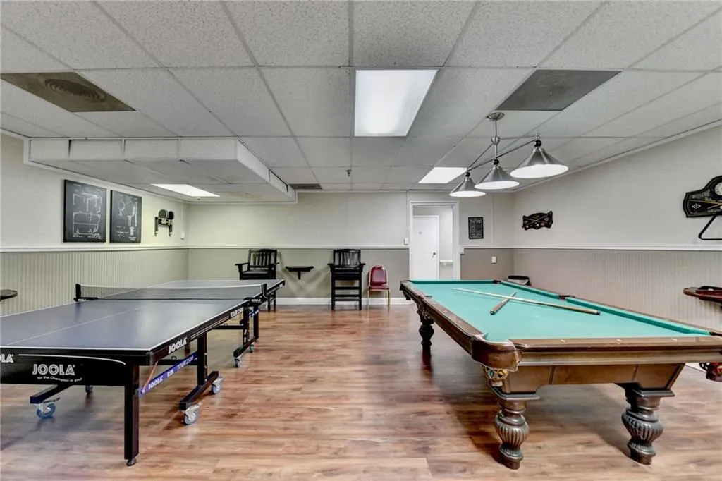 Game room with wainscoting, a drop ceiling, billiards, and wood walls