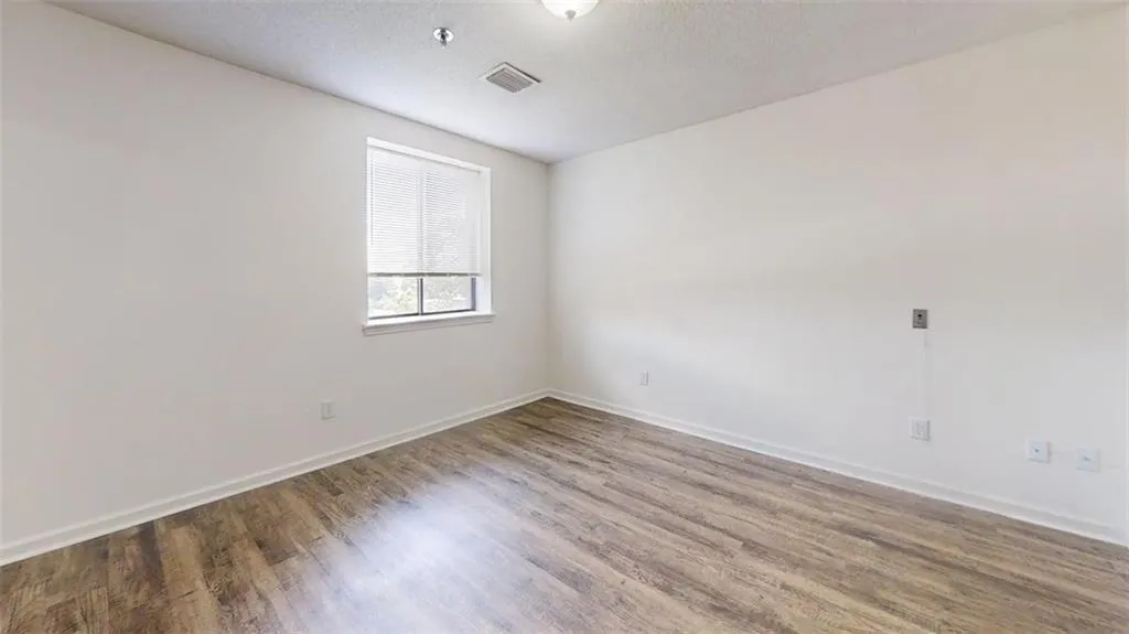 Empty room with wood finished floors and a textured ceiling