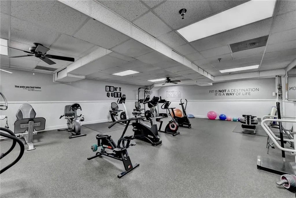 Workout area featuring ceiling fan and a paneled ceiling