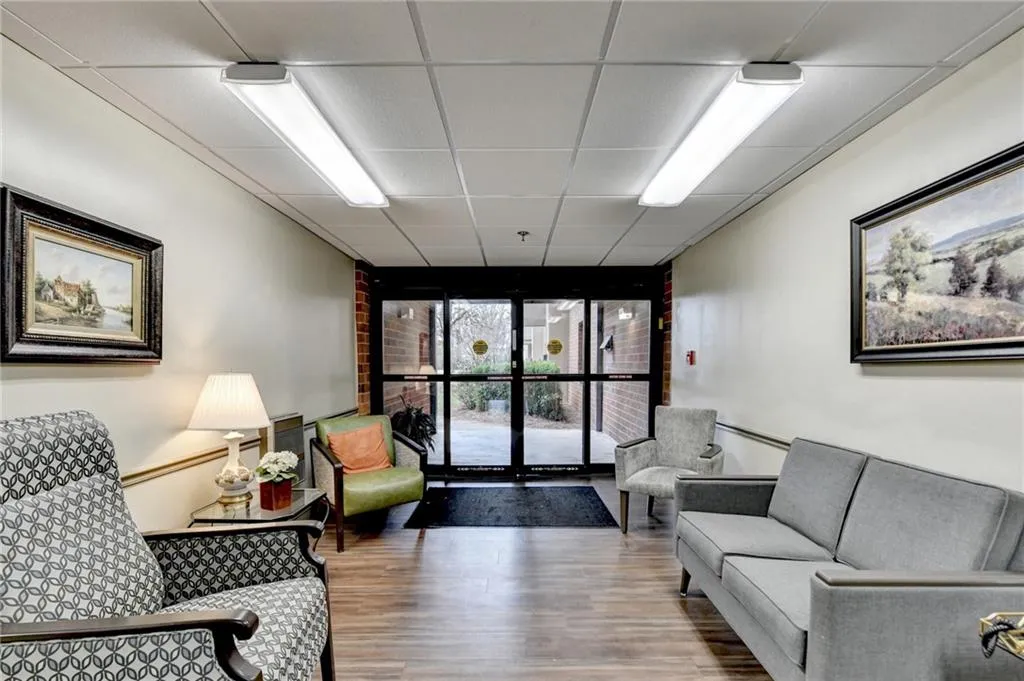 Common area with expansive windows and a drop ceiling