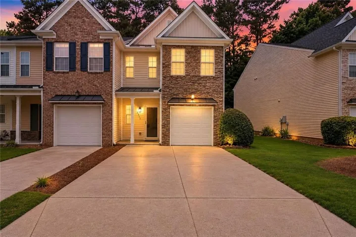 Two-story townhome featuring a stone and siding exterior with an attached single-car garage