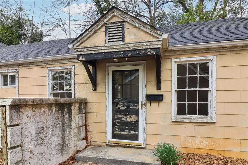 View of exterior entry with roof with shingles