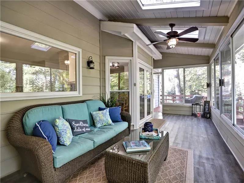 Sunroom featuring lofted ceiling with skylight, ceiling fan, and a healthy amount of sunlight