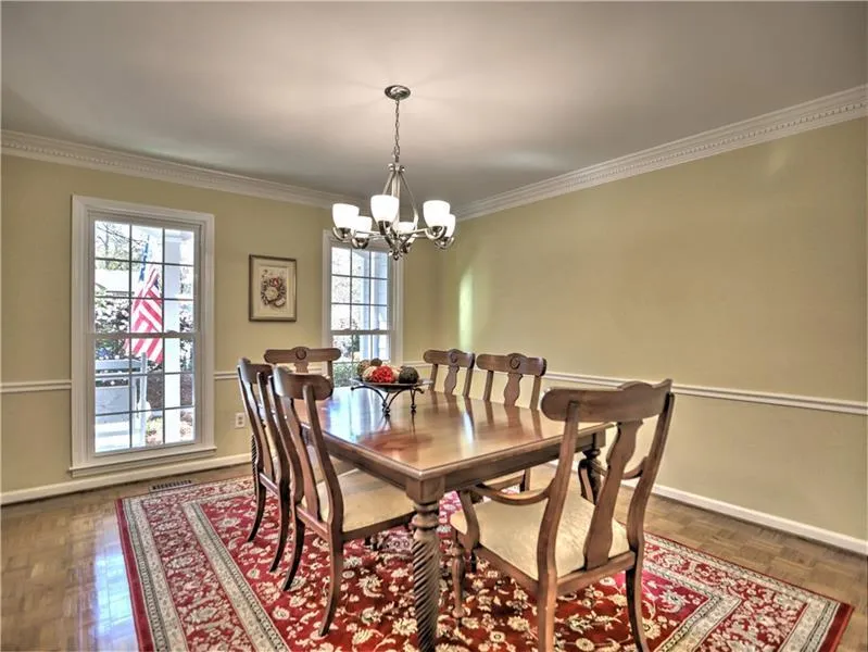 Dining space featuring dark parquet floors, an inviting chandelier, and ornamental molding