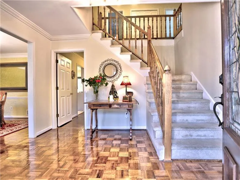 Foyer entrance with crown molding and parquet floors