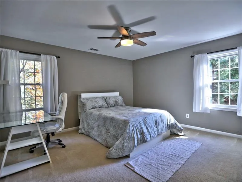Bedroom featuring ceiling fan and carpet