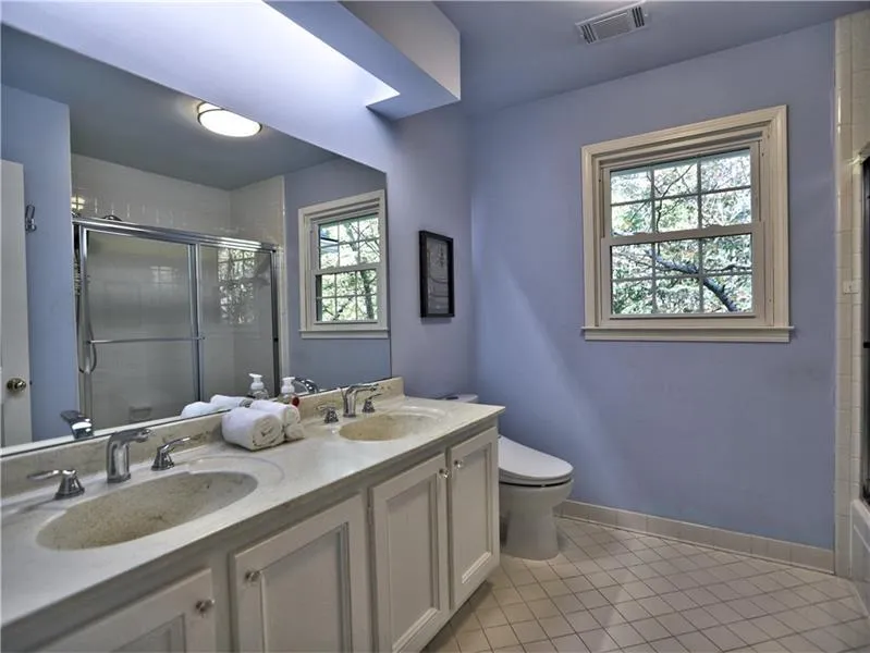 Bathroom with tile patterned flooring, an enclosed shower, and a wealth of natural light