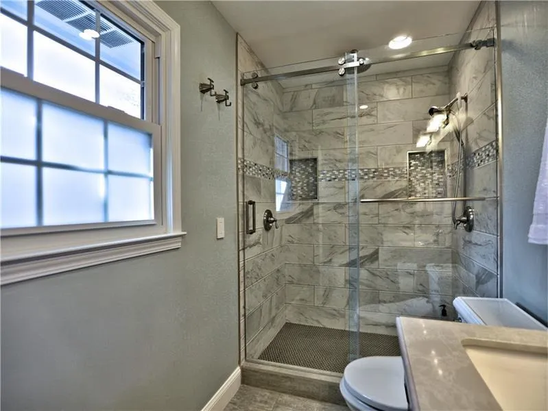 Bathroom featuring toilet, an enclosed shower, and vanity