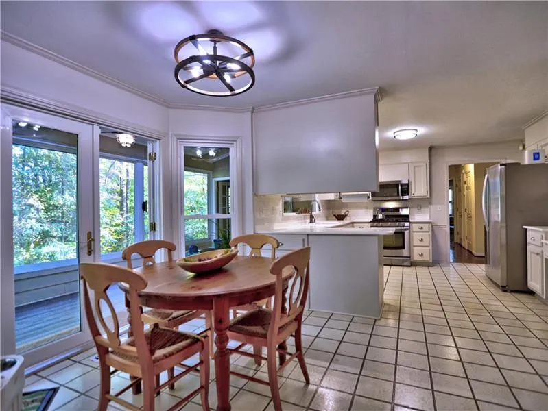 Tiled dining area featuring crown molding, sink, and a chandelier