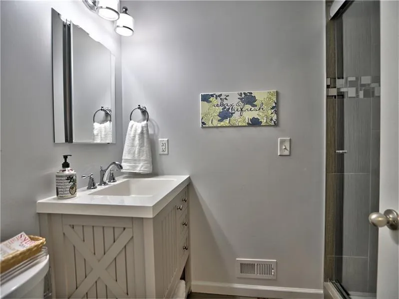 Bathroom with toilet, vanity, and walk in shower
