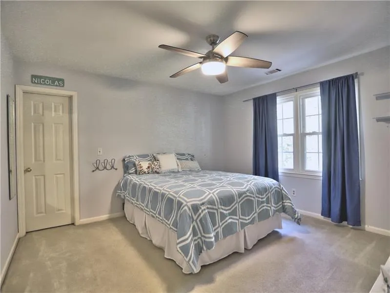 Carpeted bedroom with ceiling fan