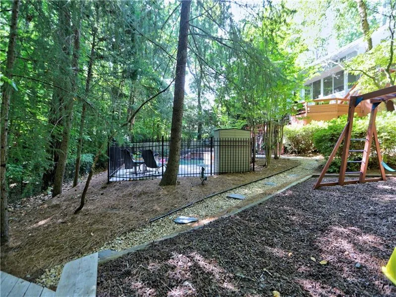 View of yard with a fenced in pool and a playground