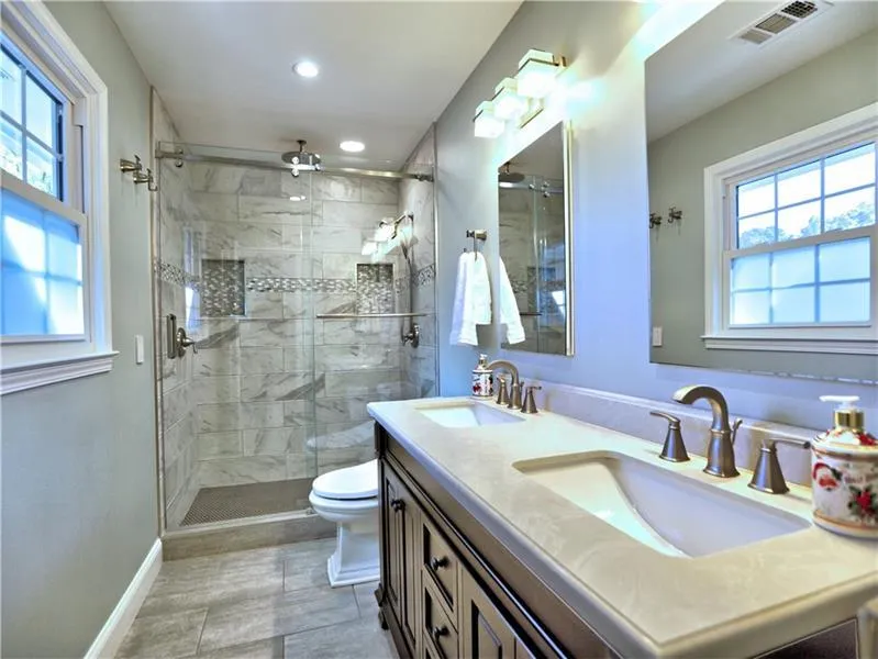 Bathroom with tile patterned floors, vanity, toilet, and a healthy amount of sunlight