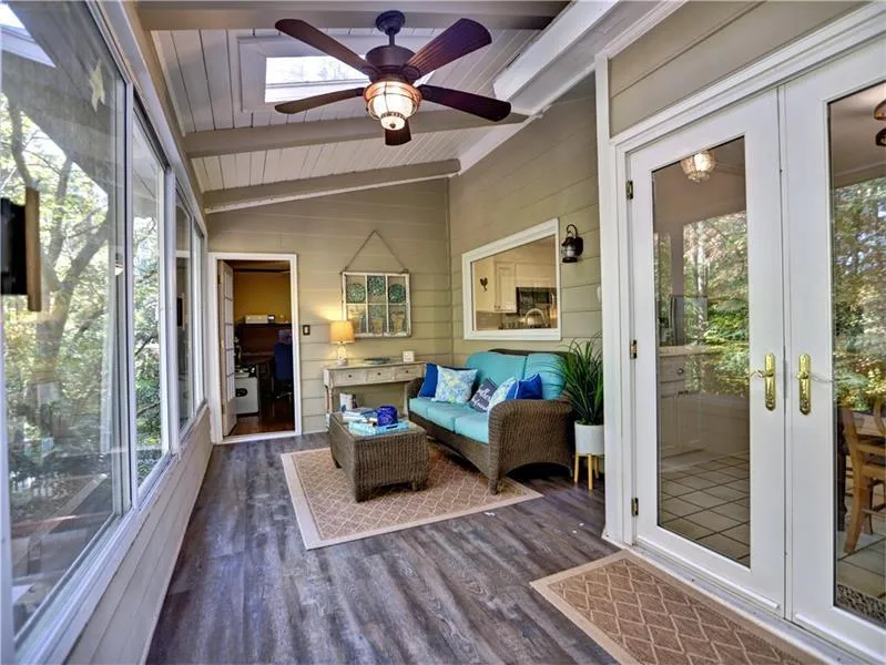Sunroom with a healthy amount of sunlight, french doors, ceiling fan, and lofted ceiling with beams