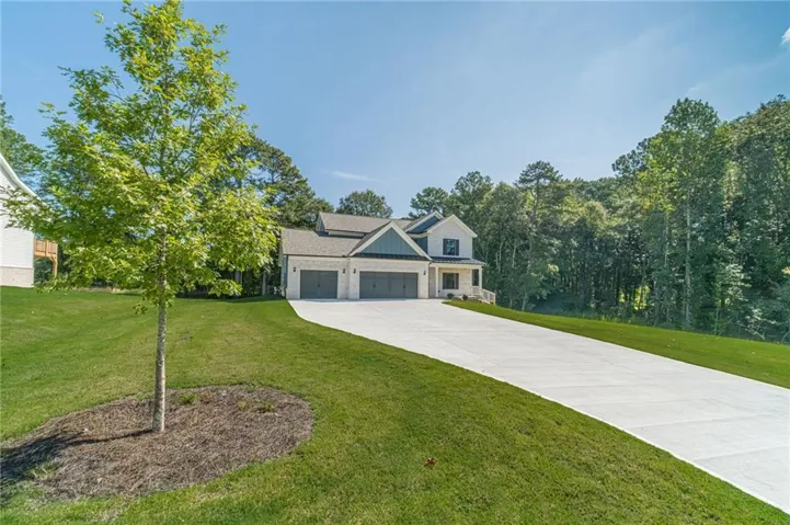 Modern farmhouse-style residence featuring a prominent front gable, a two-car garage, and a concrete driveway