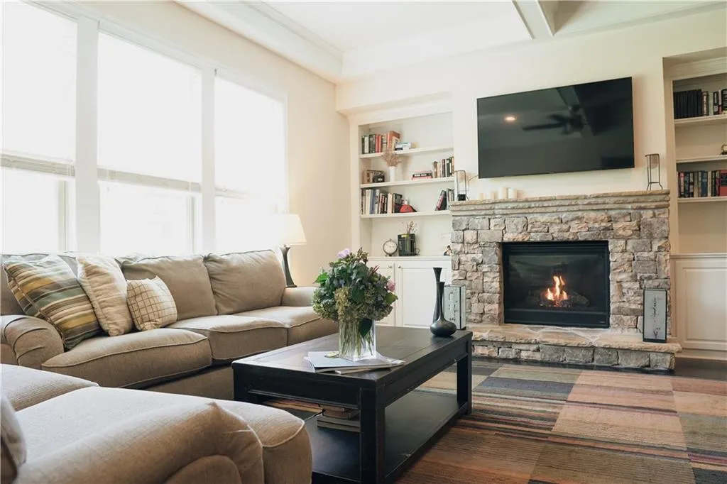Living room featuring built in features and a stone fireplace