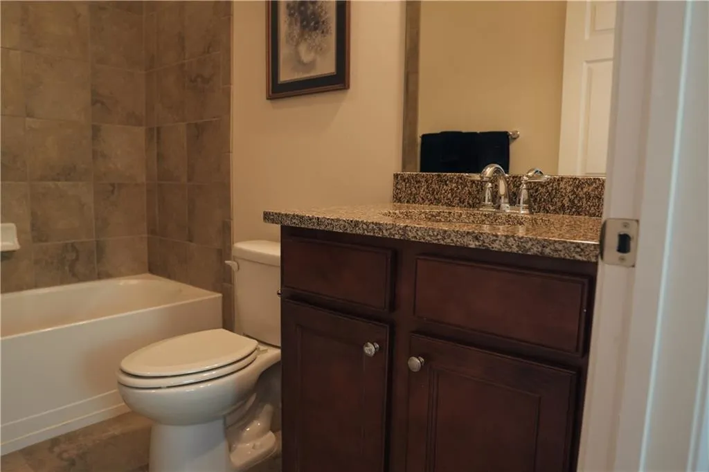 Full bathroom featuring vanity, toilet, tile patterned floors, and  shower combination